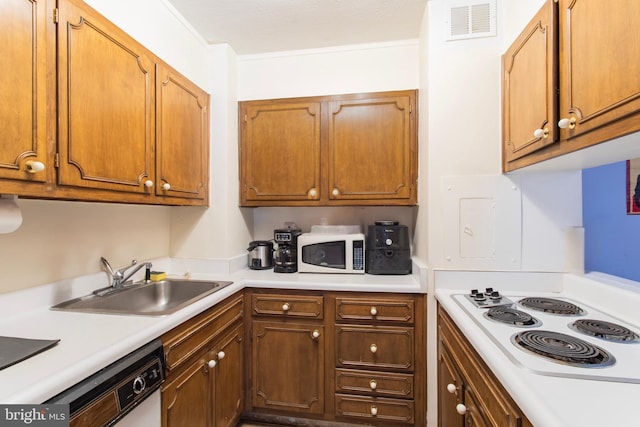 kitchen featuring a sink, white appliances, light countertops, and brown cabinets