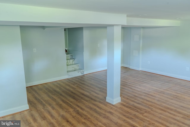 finished below grade area with baseboards and wood finished floors