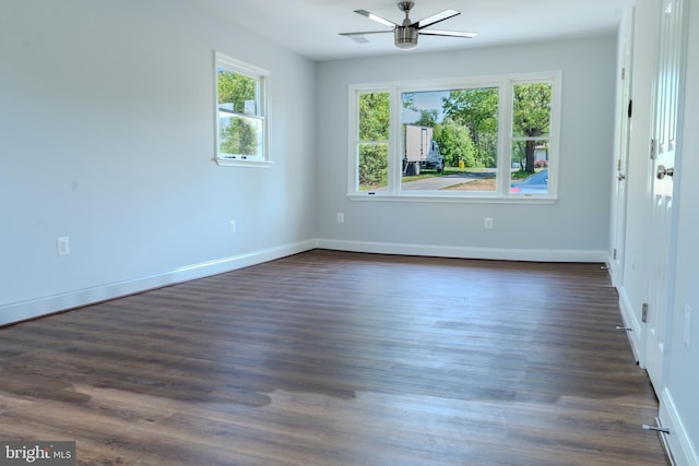 empty room with baseboards, a ceiling fan, and dark wood-style floors