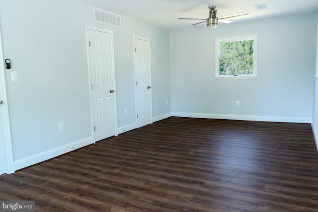 interior space featuring baseboards, dark wood-type flooring, multiple closets, and visible vents