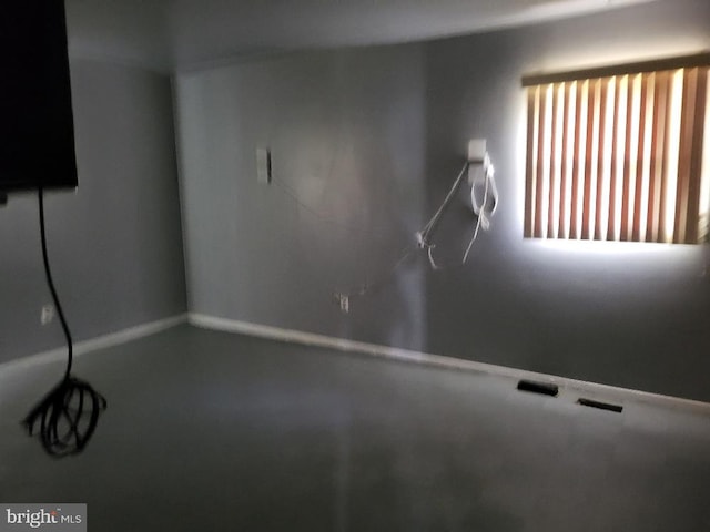spare room with baseboards