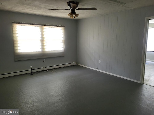 empty room with baseboards, a baseboard radiator, ceiling fan, and wood walls