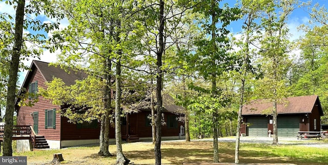 view of front of house featuring driveway and roof with shingles