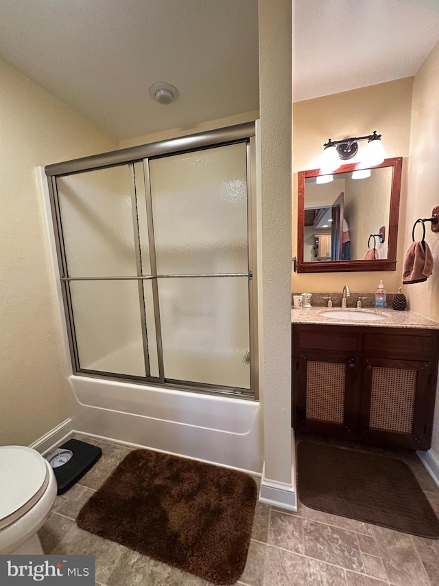 full bathroom with toilet, baseboards, bath / shower combo with glass door, and vanity