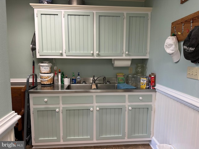 laundry area featuring wainscoting and a sink