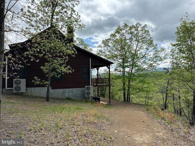 view of side of property with ac unit and driveway