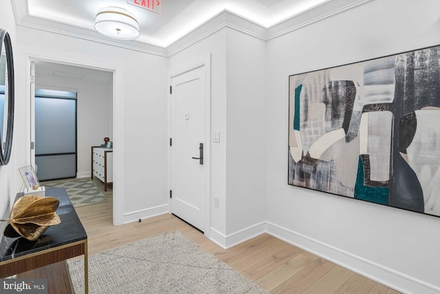 entrance foyer with baseboards, ornamental molding, and wood finished floors