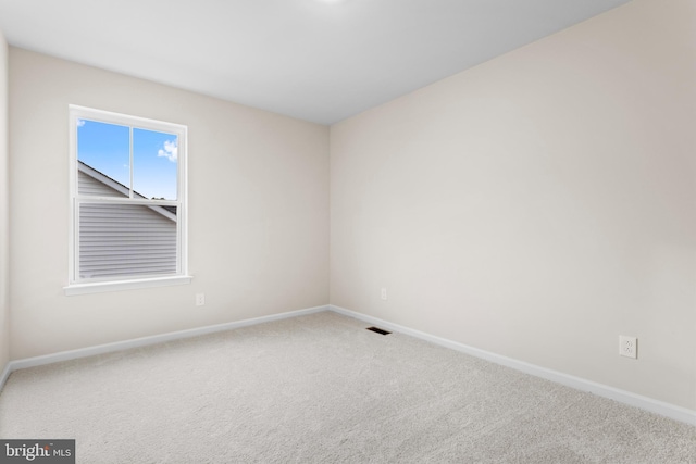 unfurnished room featuring carpet floors and baseboards