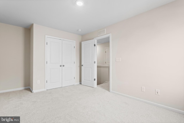 unfurnished bedroom with carpet floors, baseboards, visible vents, and a closet