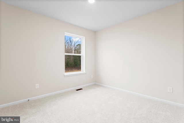 unfurnished room featuring baseboards, visible vents, and carpet