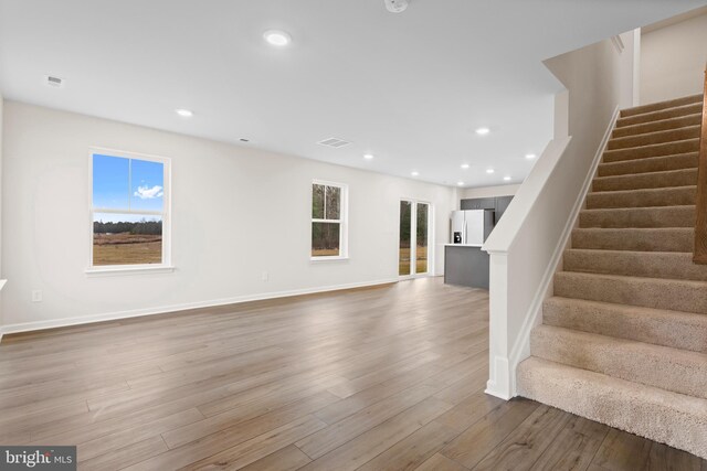 interior space featuring recessed lighting, a wealth of natural light, stairway, and wood finished floors