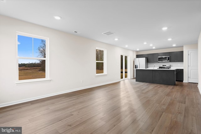 unfurnished living room featuring visible vents, recessed lighting, baseboards, and wood finished floors