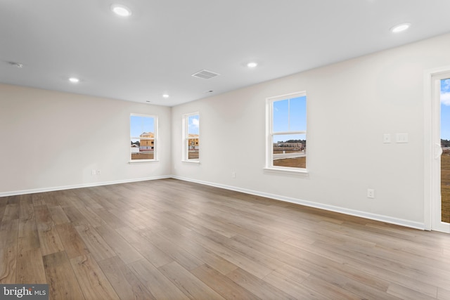 spare room featuring visible vents, a wealth of natural light, and wood finished floors