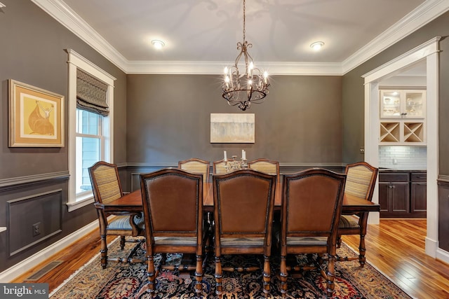 7312 Gordons Rd, Falls Church, VA 22043 - dining space featuring a chandelier, hardwood / wood-style flooring, ornamental molding, and wainscoting
