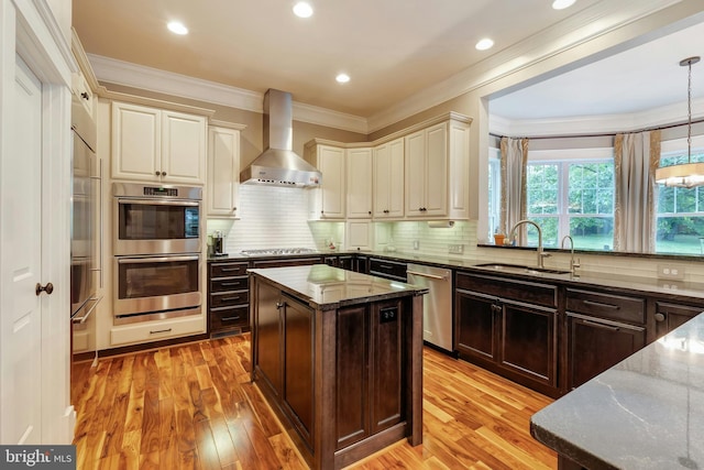 7312 Gordons Rd, Falls Church, VA 22043 - kitchen featuring wall chimney range hood, appliances with stainless steel finishes, dark stone countertops, a sink, and light wood finished floors