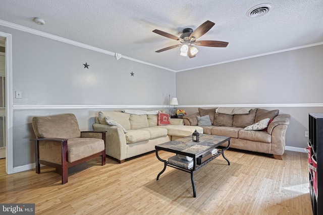 living area featuring a ceiling fan, a textured ceiling, and light wood finished floors