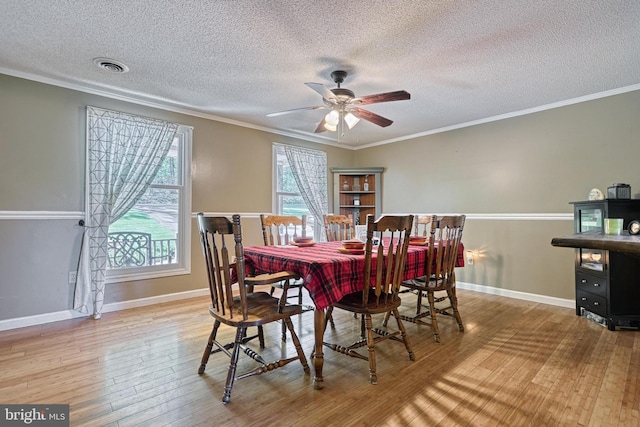 dining area featuring visible vents, a ceiling fan, a textured ceiling, and hardwood / wood-style flooring
