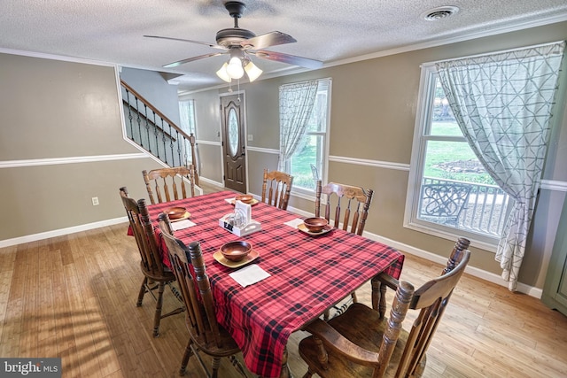 dining space with visible vents, a textured ceiling, stairs, and light wood-type flooring