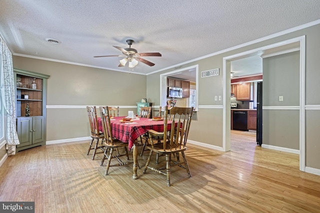 dining area featuring baseboards, ceiling fan, light wood-type flooring, and a textured ceiling