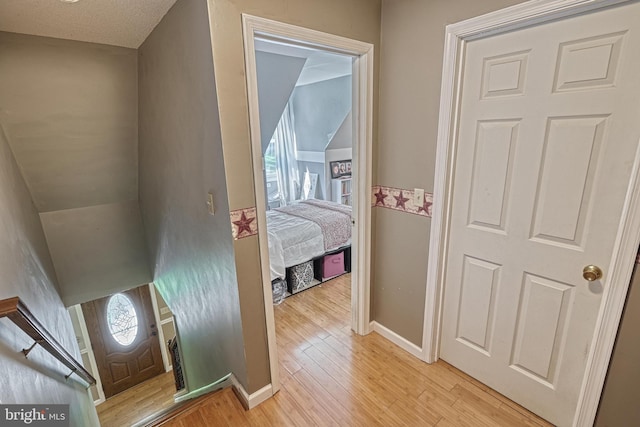 hallway with baseboards and light wood-style flooring