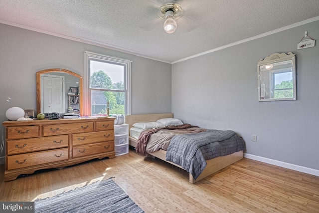 bedroom featuring light wood-type flooring, ornamental molding, a textured ceiling, and ceiling fan