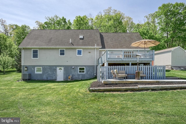 back of property with a yard, a shingled roof, cooling unit, and a deck