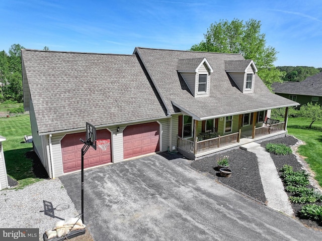 view of front of property with a shingled roof, an attached garage, a porch, and aphalt driveway
