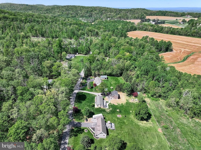 birds eye view of property featuring a forest view