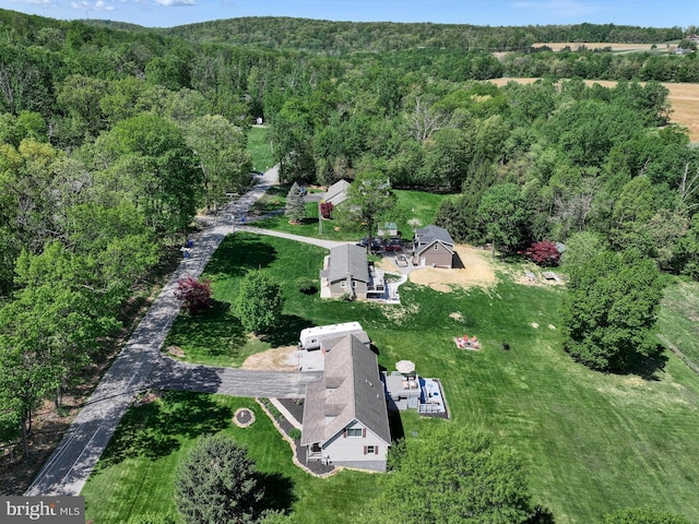 birds eye view of property featuring a forest view
