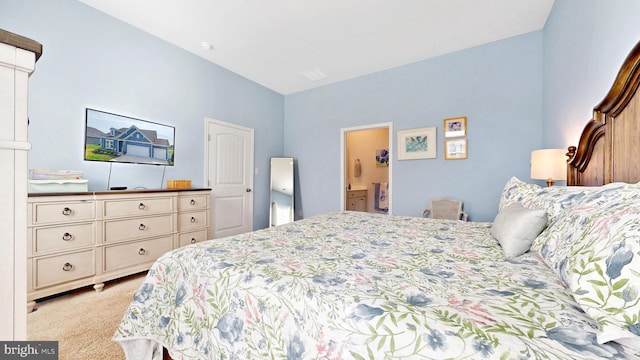 bedroom featuring light carpet and ensuite bathroom