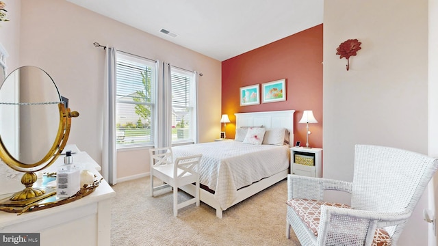bedroom with light colored carpet, visible vents, and baseboards