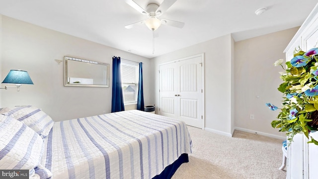bedroom with light colored carpet, a closet, baseboards, and a ceiling fan