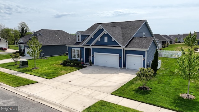 view of front facade featuring a residential view, fence, concrete driveway, a front yard, and roof with shingles