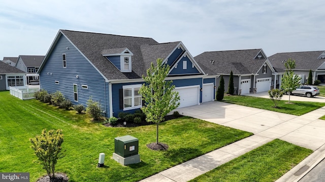 view of front of property featuring an attached garage, a residential view, a shingled roof, concrete driveway, and a front lawn