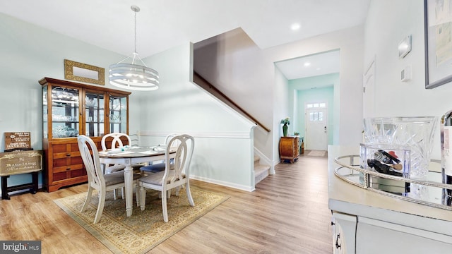 dining space featuring an inviting chandelier, stairs, light wood-type flooring, and recessed lighting