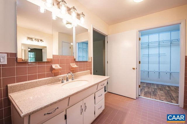 bathroom featuring tile walls, tile patterned flooring, and vanity