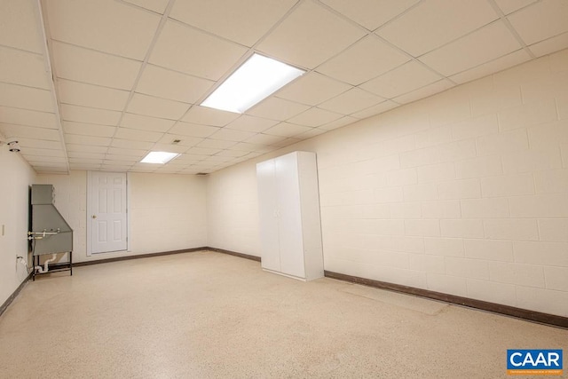 finished below grade area with baseboards and a drop ceiling