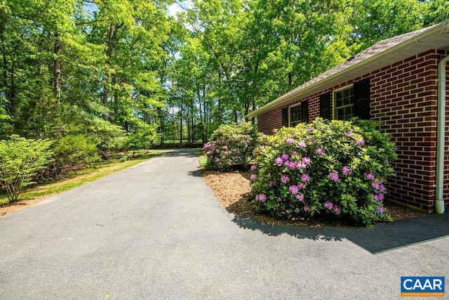 view of side of property with brick siding and aphalt driveway
