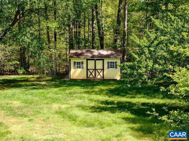 view of shed with a wooded view and fence