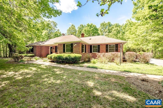 ranch-style house featuring a chimney, brick siding, and a front lawn