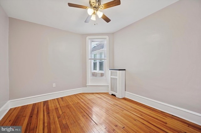 empty room featuring baseboards, ceiling fan, and hardwood / wood-style flooring