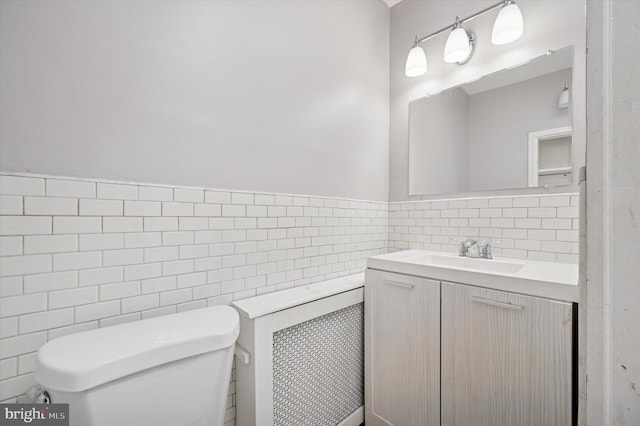 bathroom with tile walls, vanity, and toilet