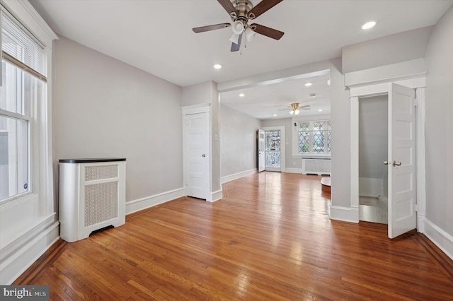 unfurnished living room with baseboards, a ceiling fan, and light wood-style flooring