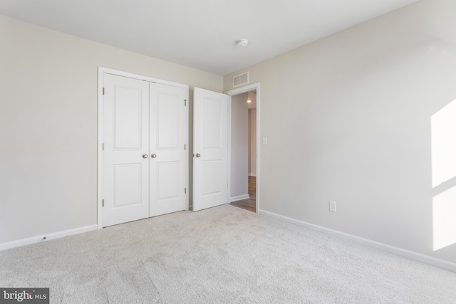 unfurnished bedroom with visible vents, baseboards, carpet floors, and a closet