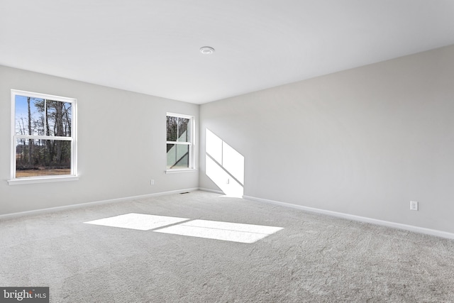 spare room featuring baseboards and carpet
