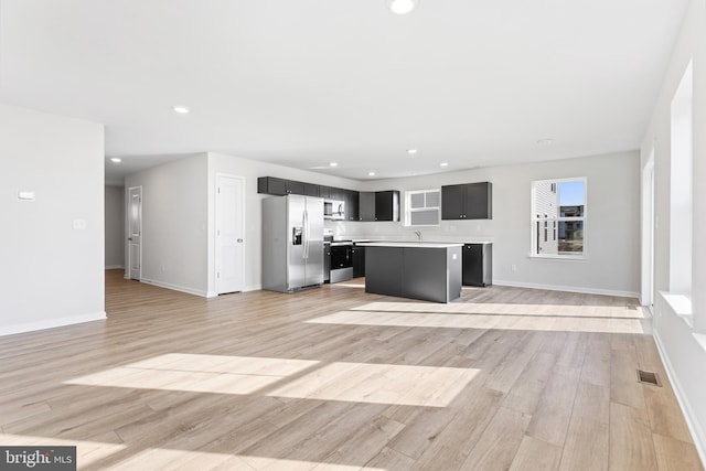 unfurnished living room featuring visible vents, recessed lighting, light wood-style floors, and baseboards