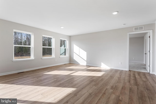 unfurnished living room featuring baseboards, recessed lighting, wood finished floors, and visible vents