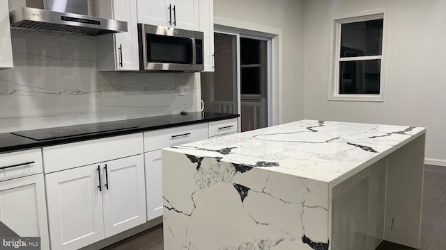 123 Cumberland St, Cumberland, MD 21502 - kitchen with a kitchen island, wall chimney exhaust hood, stainless steel microwave, white cabinets, and backsplash