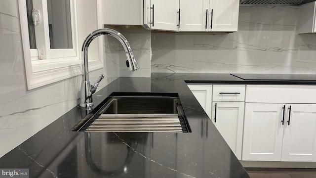 123 Cumberland St, Cumberland, MD 21502 - details featuring black electric cooktop, decorative backsplash, a sink, and white cabinets