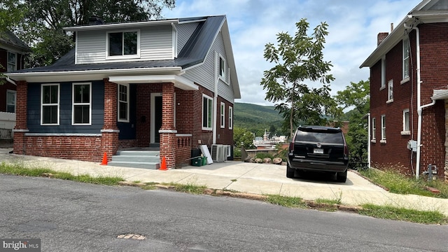 123 Cumberland St, Cumberland, MD 21502 - view of property exterior with brick siding, a mountain view, central AC, and metal roof